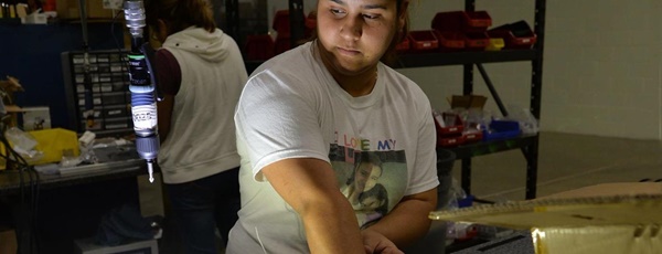Autronic Plastics worker operates a precision drill for an LED light