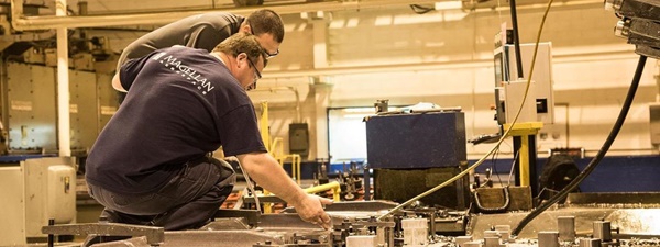 Magellan Aerospace workers inspect precision cut metal aircraft parts